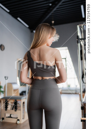 Pilates fitness trainer beautiful back relief. Pilates studio. Young sporty attractive woman wearing sportswear in yoga studio. Fit, healthy and strong authentical body. Fitness concept Pilates fitness trainer beautiful back relief. Pilates studio. Young sporty attractive woman wearing sportswear in yoga studio. Fit, healthy and strong authentical body. Fitness concept 117034769