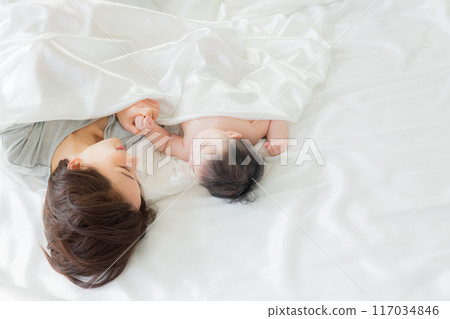 Baby sleeping next to mother 117034846