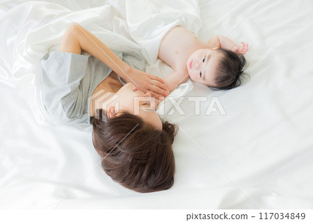 Baby sleeping next to mother Baby sleeping next to mother 117034849