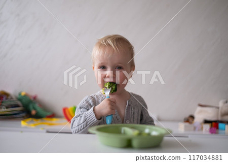 Child little girl eats vegetable salad using fork Child little girl eats vegetable salad using fork 117034881