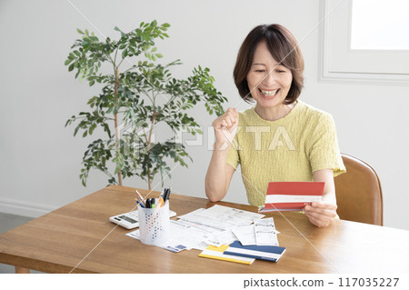 拿著存款簿的笑的婦女 拿著存款簿的笑的婦女 117035227