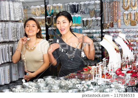 Happy women choosing stylish adornments in bijouterie boutique 117036533