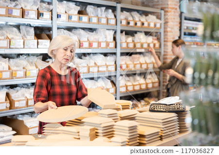 Elderly woman chooses blanks for making pottery Elderly woman chooses blanks for making pottery 117036827