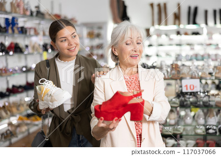 Elderly woman and young woman choosing mules and sneakers Elderly woman and young woman choosing mules and sneakers 117037066