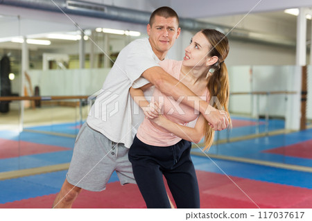 Young woman exercising elbow strike during self-protection training 117037617