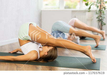 Mom, grandma and teenage daughter do Halasana plow pose. Mom, grandma and teenage daughter do Halasana plow pose. 117037619