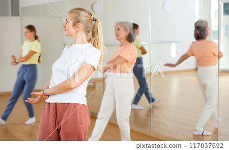 Female doing dance workout during group classe in fitness center 117037692