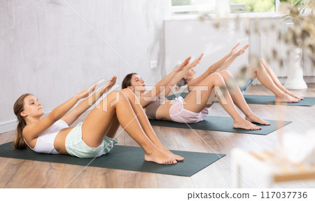 Mom, grandma and teenage daughter do exercises to strengthen press, pump muscles of core 117037736