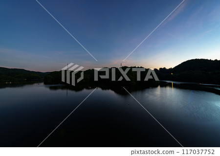 Scenery of Nunome Dam on the eastern edge of Nara City. The open sky and lake surface on the south side of the dam. Fixed tripod interval photography. Starry sky from before sunset #98 117037752