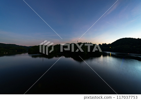 Scenery of Nunome Dam on the eastern edge of Nara City. The open sky and lake surface on the south side of the dam. Fixed tripod interval photography. Starry sky from before sunset #99 117037753