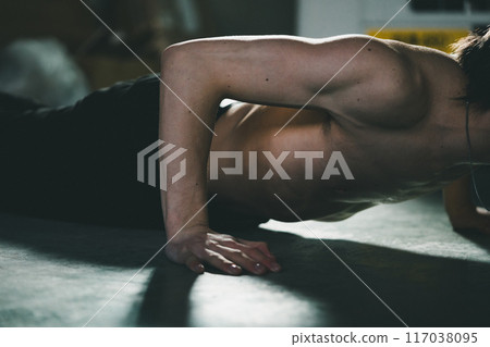一個男人在車庫裡做伏地挺身 117038095
