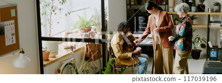 Diverse gen Z colleagues wearing stylish outfits chatting during break in modern biophilic office of leading IT company, header for website Diverse gen Z colleagues wearing stylish outfits chatting during break in modern biophilic office of leading IT company, header for website 117039196
