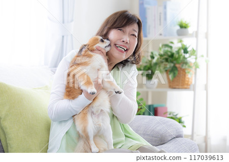 Senior woman relaxing with her pet dog 117039613