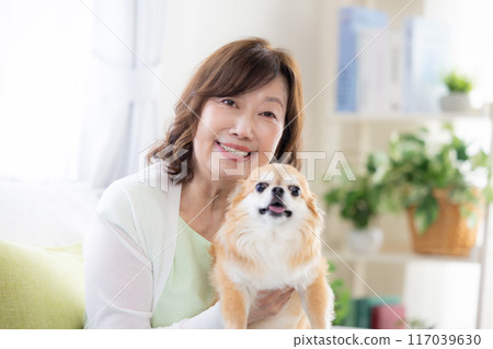 Senior woman relaxing with her pet dog Senior woman relaxing with her pet dog 117039630