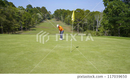 Golfer are playing game golf and hitting go on green grass mountain background. Golfer are playing game golf and hitting go on green grass mountain background. 117039650