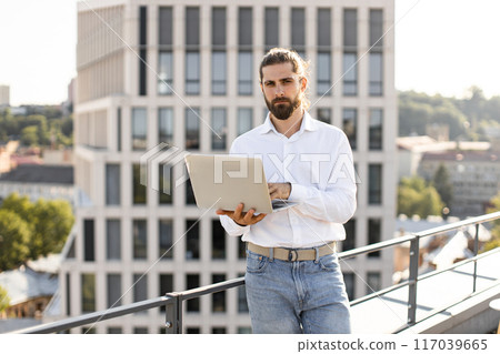Business professional working on laptop outdoors on a rooftop Business professional working on laptop outdoors on a rooftop 117039665
