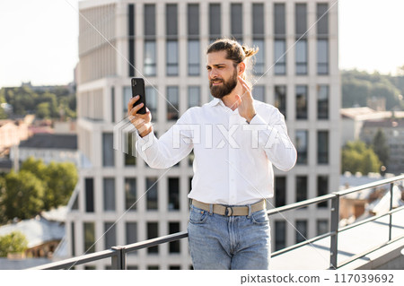 Man having video call on rooftop with cityscape background Man having video call on rooftop with cityscape background 117039692