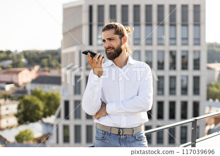 Man talking on smartphone outdoors in urban setting Man talking on smartphone outdoors in urban setting 117039696