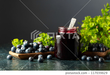 Blueberry jam and fresh berries with leaves. 117039829