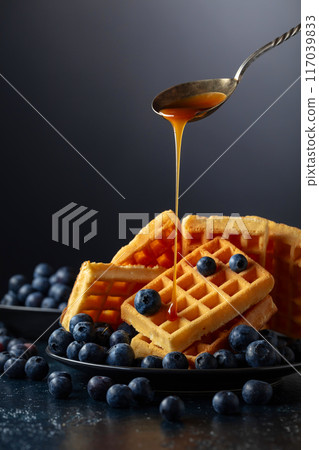 Belgian waffles with fresh blueberries and caramel sauce. Belgian waffles with fresh blueberries and caramel sauce. 117039833
