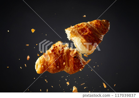 Croissant in air on a black background. Croissant in air on a black background. 117039837