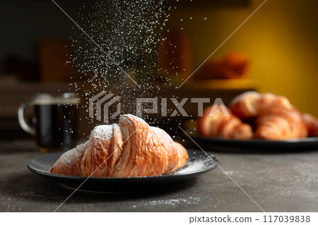 Croissants sprinkled with sugar powder. 117039838