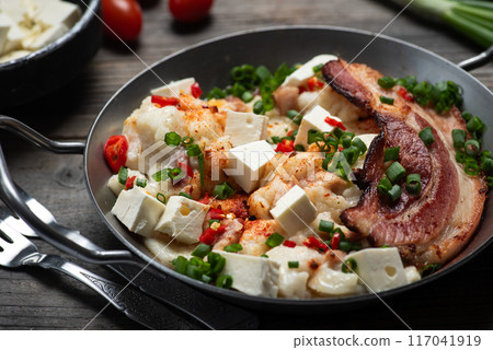 Savory skillet meal with bacon, tofu, vegetables, garnished with green onions. 117041919