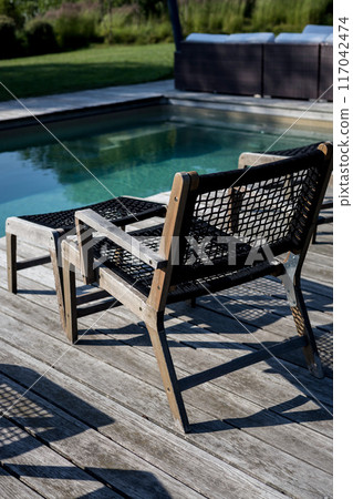 Wooden sunbeds with near swimming pool Wooden sunbeds with near swimming pool 117042474