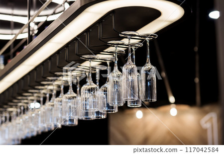 Cocktail Glasses in a Bar rack. 117042584