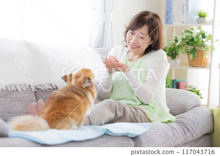 Senior woman relaxing with her pet dog Senior woman relaxing with her pet dog 117043716