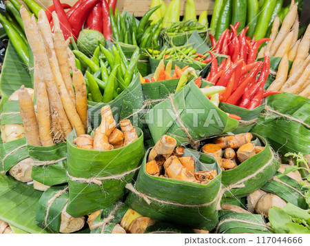 Variety of Fresh red chilies and turmeric in Banana Leaves. 117044666