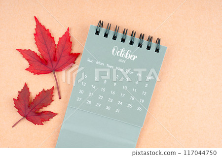 October 2024 monthly calendar and fall leaves on brown. 117044750