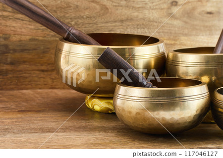 Golden Singing Bowls on a wooden surface 117046127