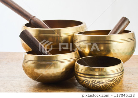 Golden Singing Bowls on a wooden surface Golden Singing Bowls on a wooden surface 117046128