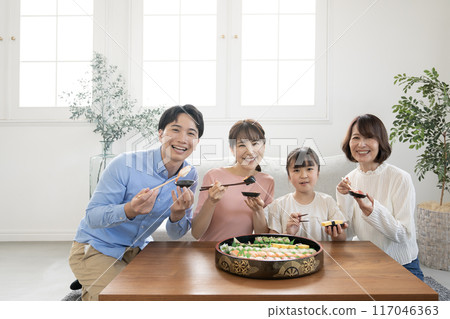 A family of four eating sushi in the living room A family of four eating sushi in the living room 117046363