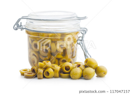 Sliced pickled green olives in brine isolated on white background. Sliced pickled green olives in brine isolated on white background. 117047157
