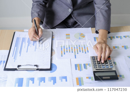 Asian businesswoman sit at their desks and calculate financial graphs showing results about their investments and plan successful business growth process Asian businesswoman sit at their desks and calculate financial graphs showing results about their investments and plan successful business growth process 117047230
