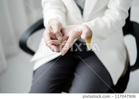 Woman hand with wrist pain numbness and pain in the palm of the hand has pain and tingling in the nerve endings This is a side effect of sitting and working for a long time on a laptop at the office Woman hand with wrist pain numbness and pain in the palm of the hand has pain and tingling in the nerve endings This is a side effect of sitting and working for a long time on a laptop at the office 117047806
