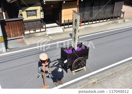 Takayama City, Gifu Prefecture, Japan: Spring Takayama Festival: A man wearing a happi coat and a jinbaori hat takes a rest after placing an old cart on the ground. Takayama City, Gifu Prefecture, Japan: Spring Takayama Festival: A man wearing a happi coat and a jinbaori hat takes a rest after placing an old cart on the ground. 117048012