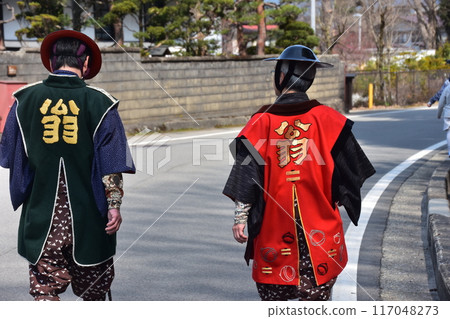 日本岐阜縣高山市，一名身著法衣、身穿 jingasa 的男子走在小巷裡參加節慶。 117048273
