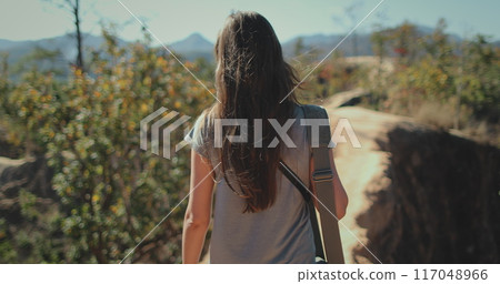 Woman tourist traveler walking Pai Canyon Kong Lan, Chiang Mai Province, Thailand. Long hair brunette with bag back view, slow motion Woman tourist traveler walking Pai Canyon Kong Lan, Chiang Mai Province, Thailand. Long hair brunette with bag back view, slow motion 117048966