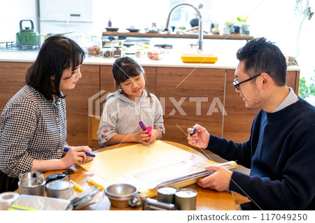 A daughter ponders as her father shows her a hazard map, while her mother looks on. 117049250