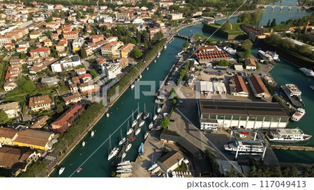 Aerial view of the city of Peschiera del Garda, Verona, Veneto. Top view of the canal with yachts Aerial view of the city of Peschiera del Garda, Verona, Veneto. Top view of the canal with yachts 117049413