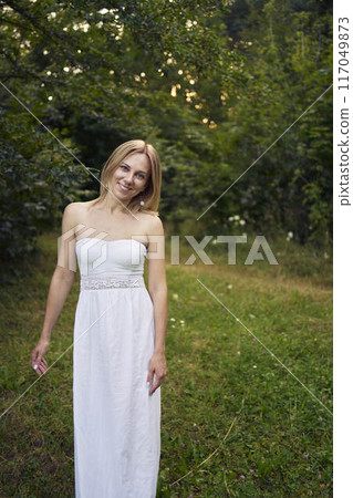 portrait of a beautiful 30-year-old woman in a white dress in the garden portrait of a beautiful 30-year-old woman in a white dress in the garden 117049873