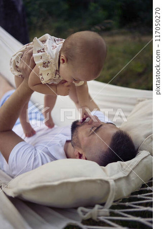dad playing with his baby daughter in a hammock dad playing with his baby daughter in a hammock 117050270