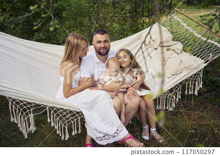 family mother father sister teenager and baby in hammock family mother father sister teenager and baby in hammock 117050297