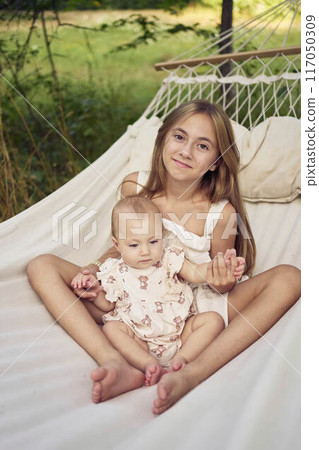 sisters, pre-teen and baby on a picnic 117050309