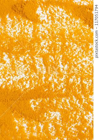 Abstract orange background of spilled turmeric powder on white background top view 117051794