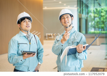 Businessmen wearing work clothes having a meeting at a construction site 117052079