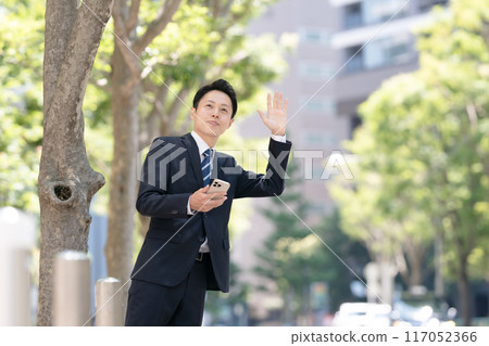 A businessman calling a taxi 117052366